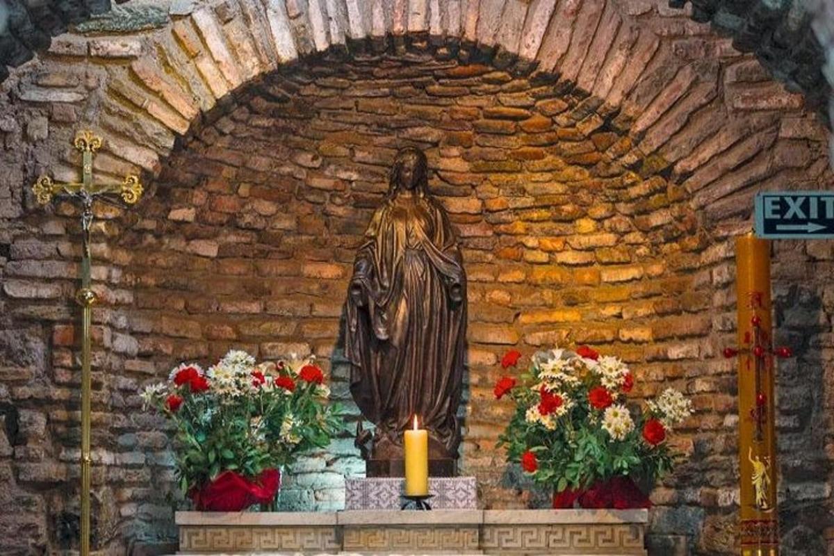 statua w kościele z kwiatami i świecą