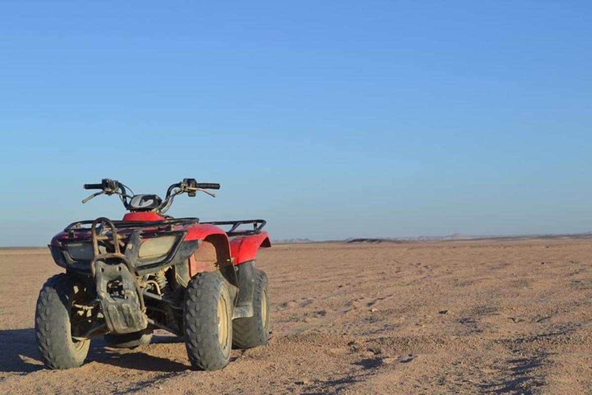 un quad vermell aparcat al mig d'un desert