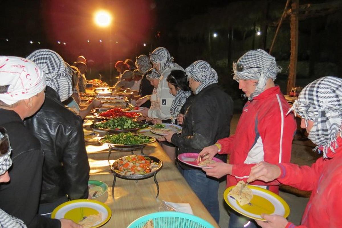 un grup de persones al voltant d'una taula amb plats de menjar