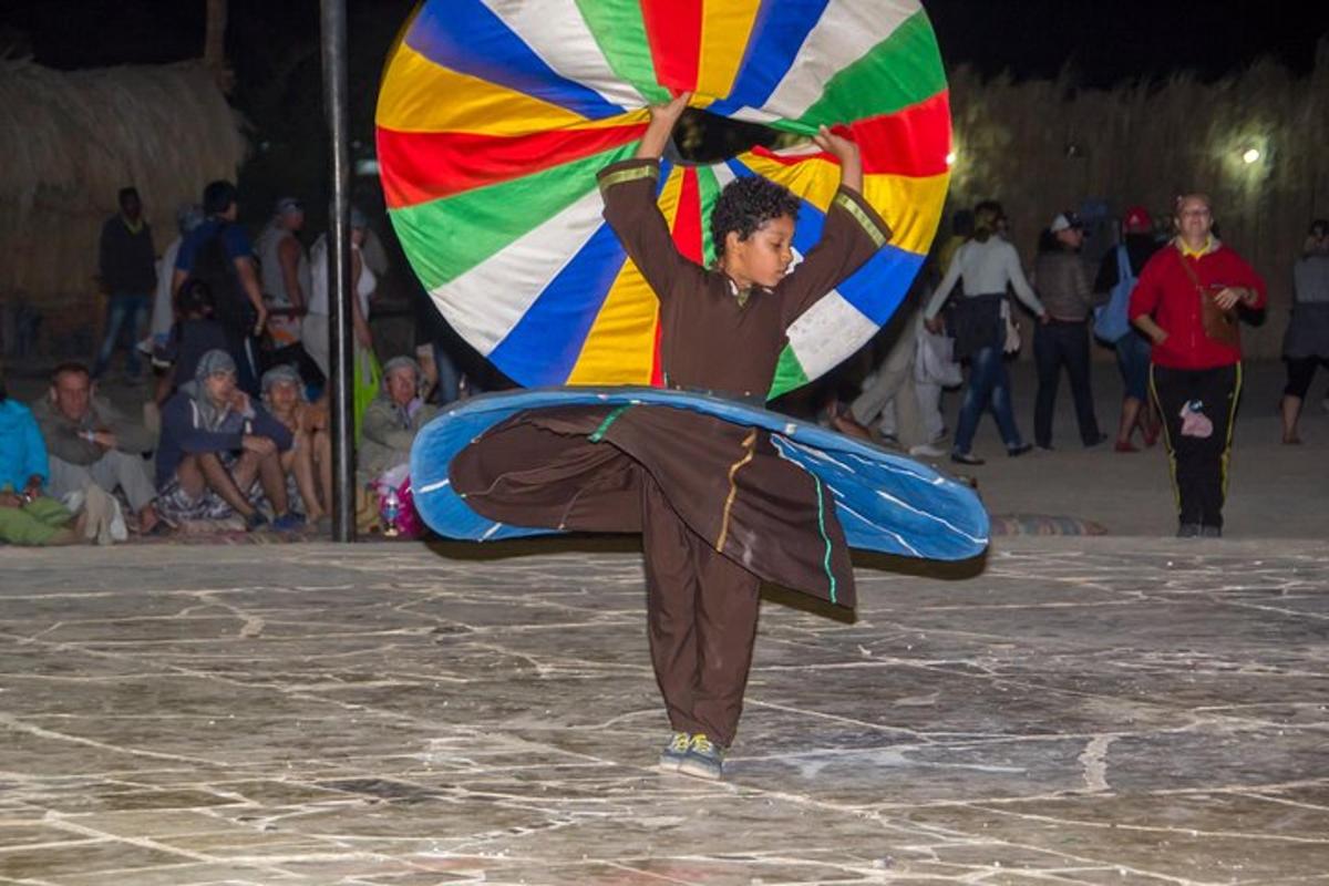 un home balla amb un paraigua de colors