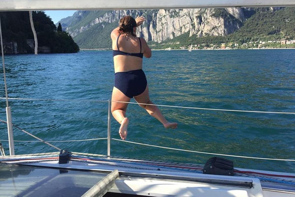 žena skákající z lodi do vody