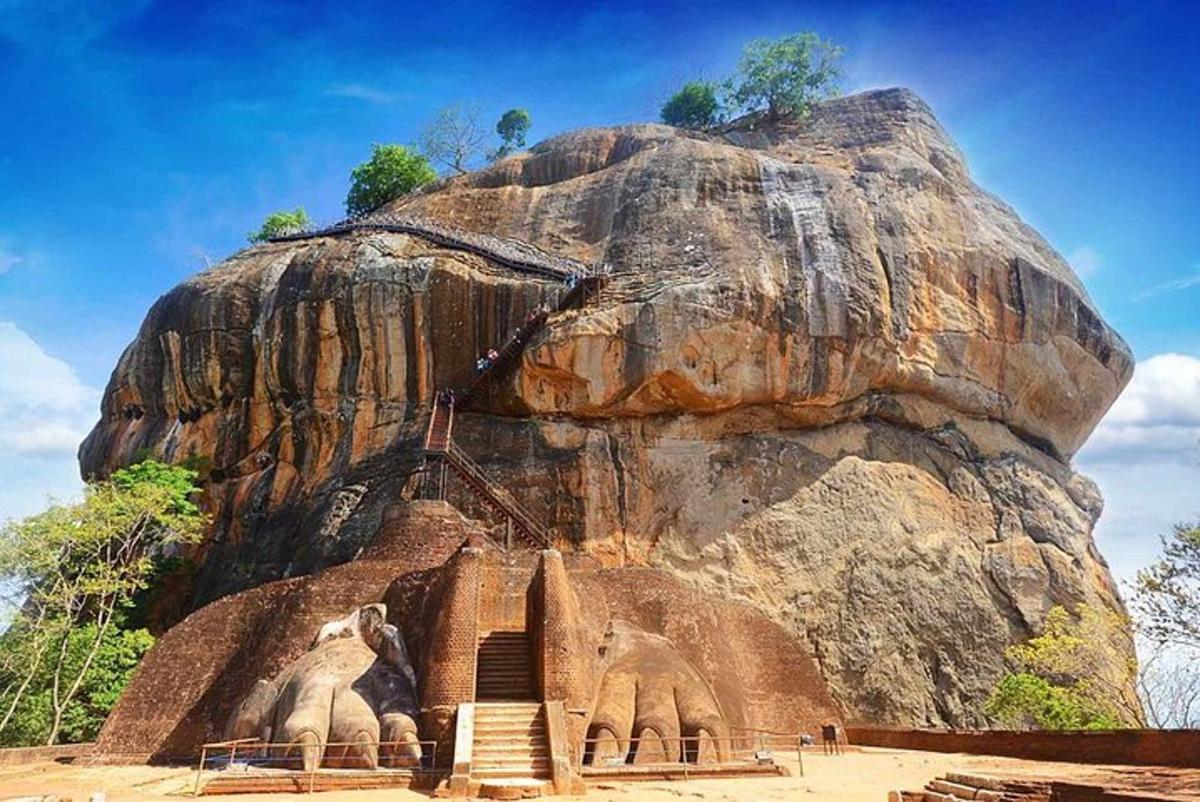 a statue of two elephants in front of a rock