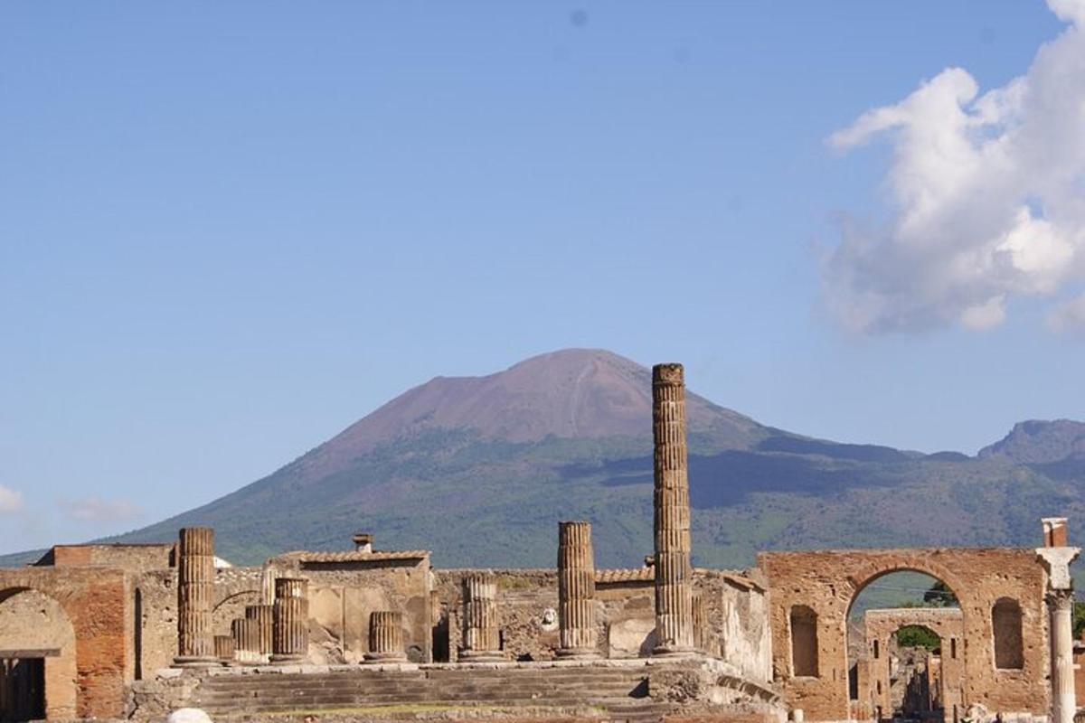 un edifici antic amb columnes i una muntanya al fons
