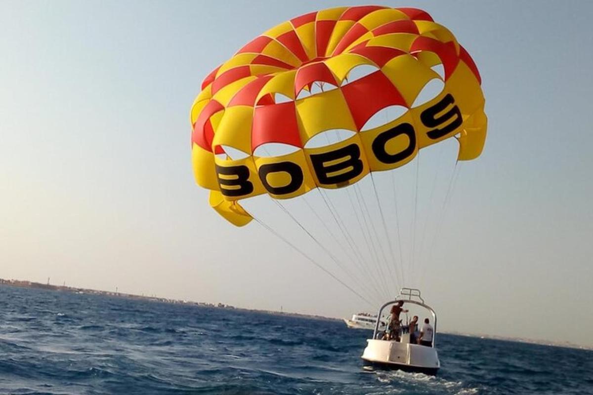 un paracadute giallo e rosso che vola sopra l'oceano