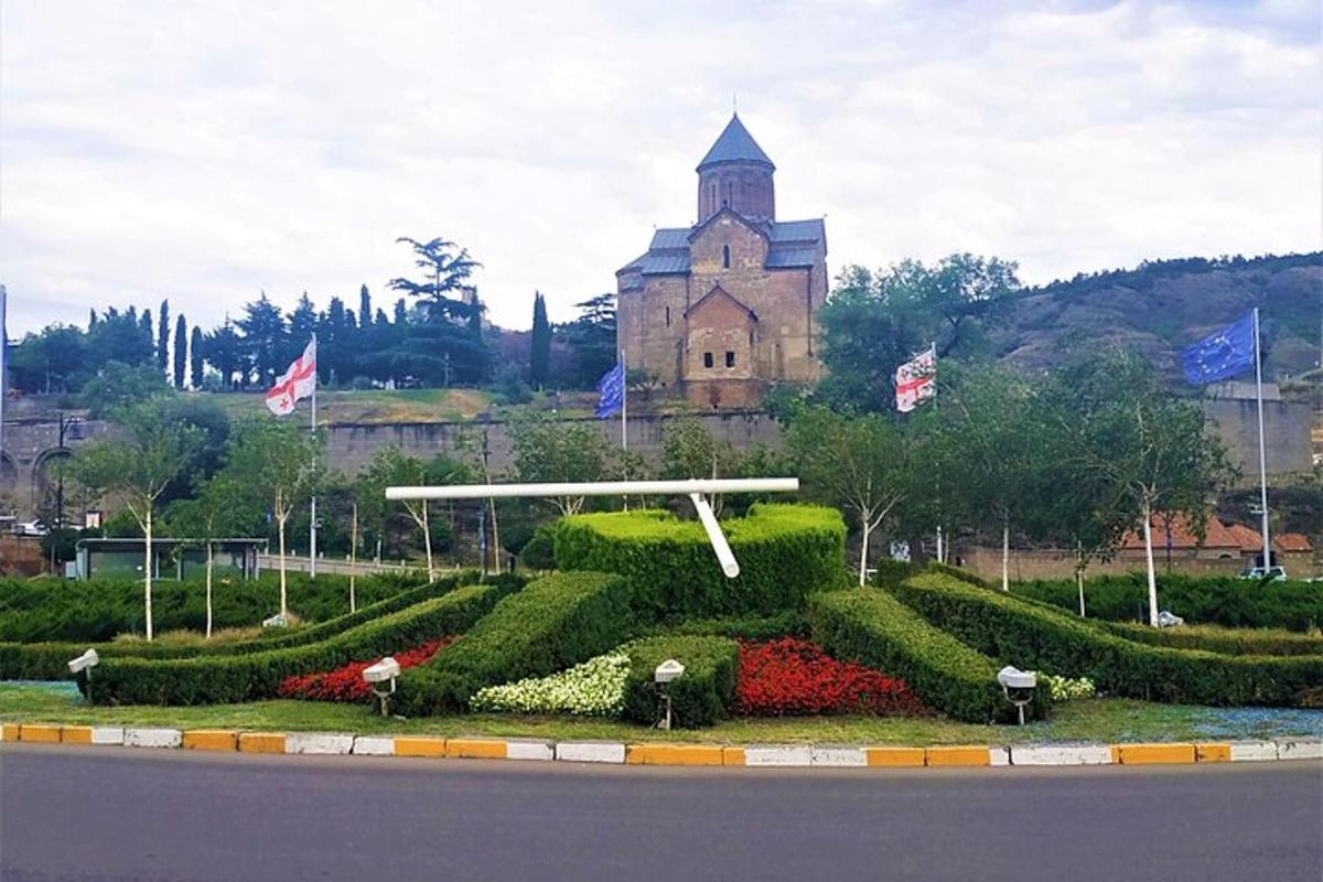 un giardino di fronte a un edificio con una torre dell'orologio