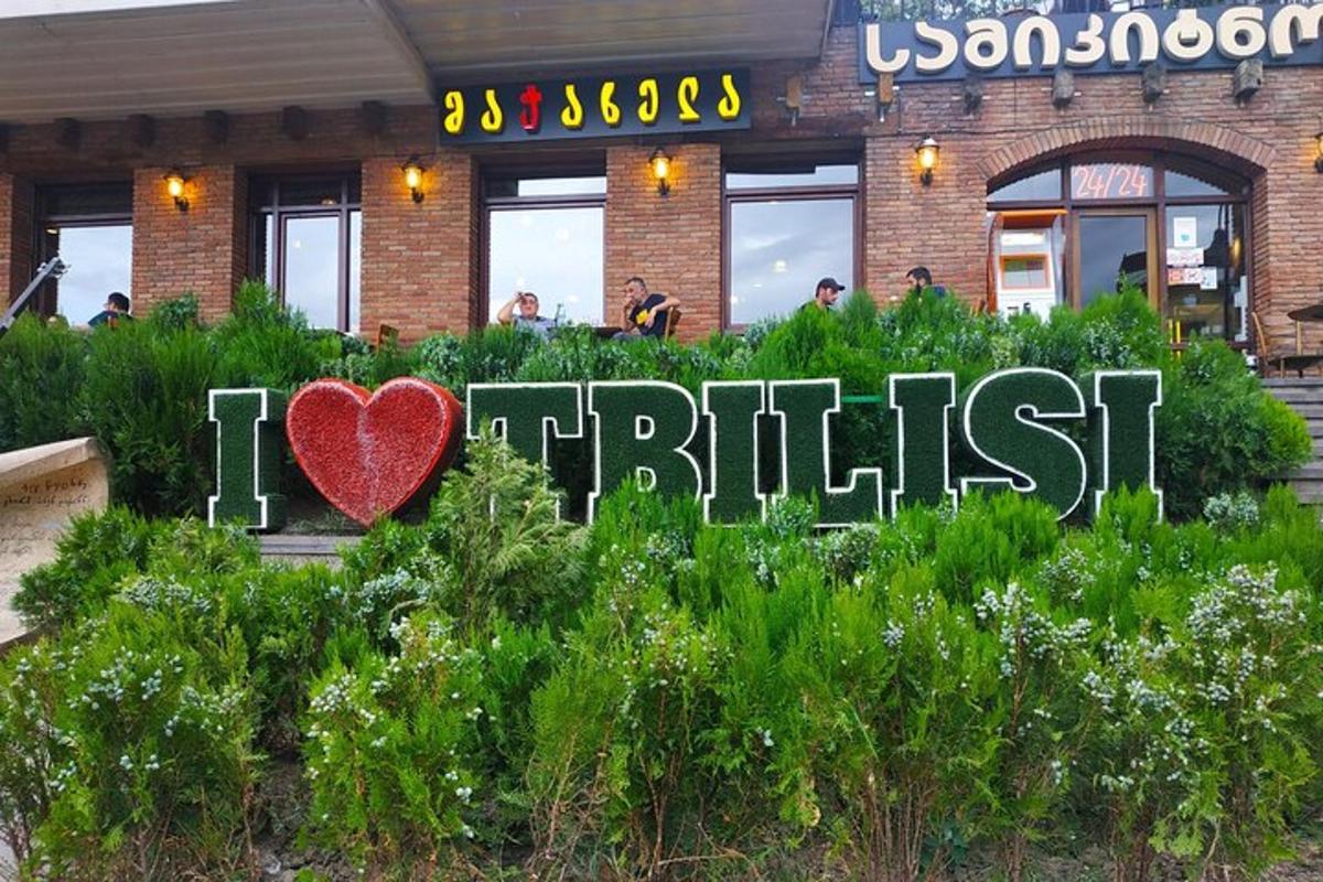 un cartello con un cuore tra i cespugli davanti a un edificio