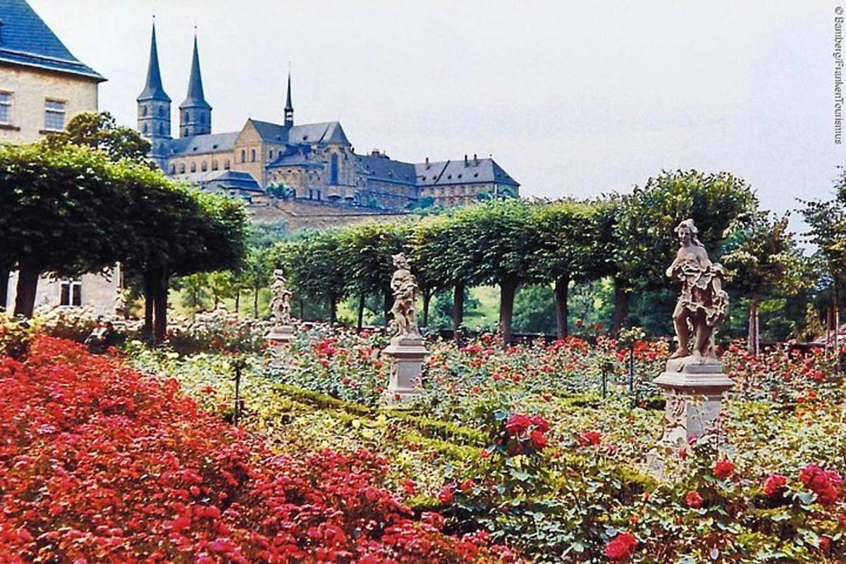 um jardim com flores e um castelo ao fundo