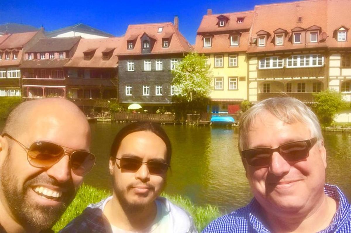three men posing for a picture in front of a river