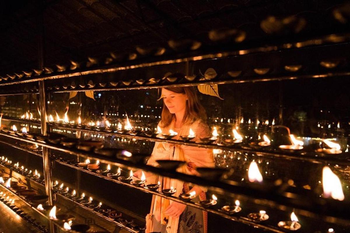 seorang wanita berdiri di depan banyak lilin