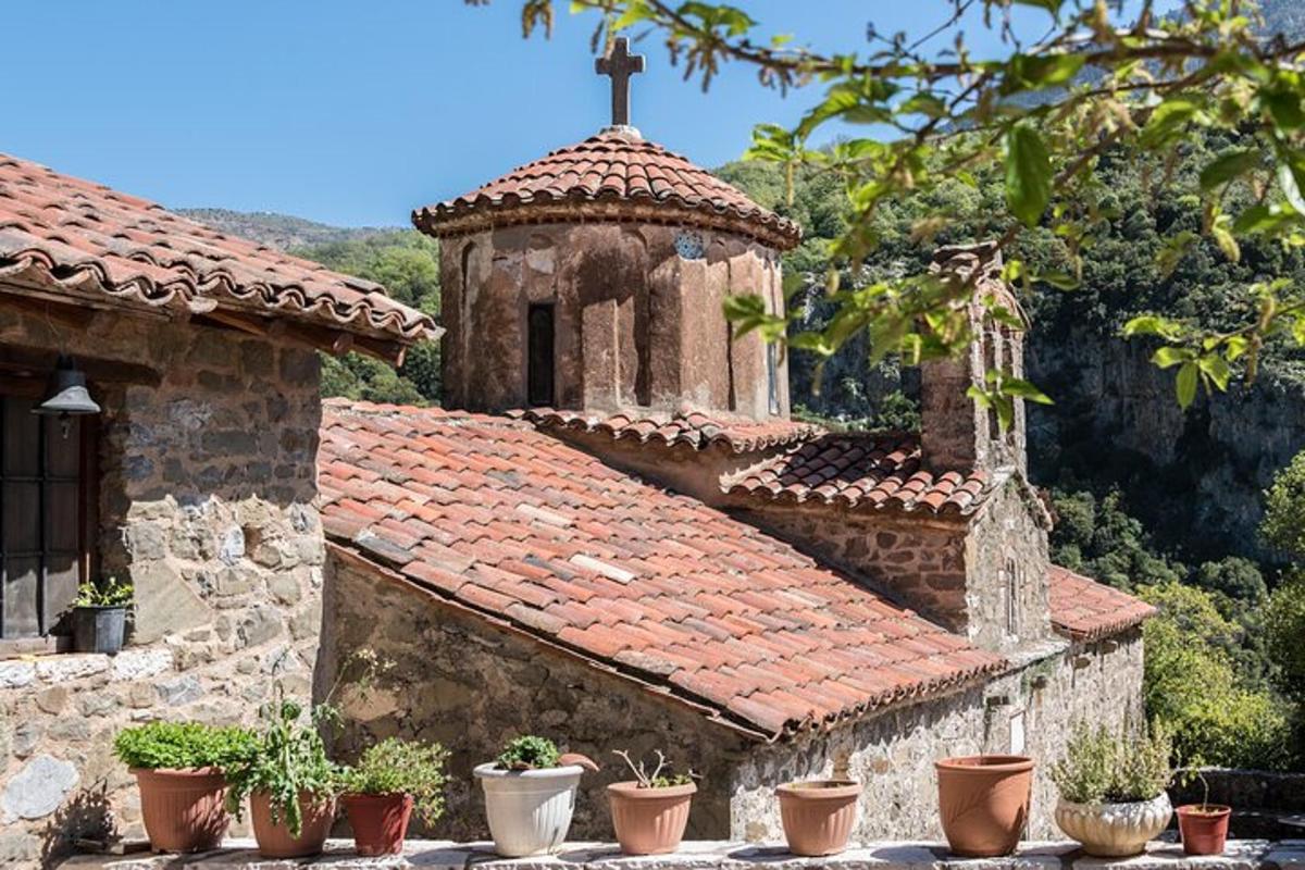ένα παλιό πέτρινο κτίριο με εκκλησία με γλάστρες με φυτά