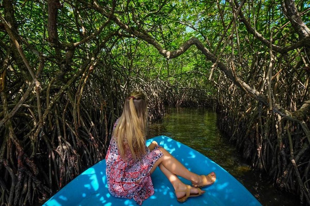 una ragazza è seduta su un kayak blu nell'acqua