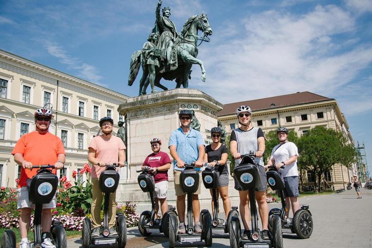 un grup de persones que van en segways davant d'una estàtua
