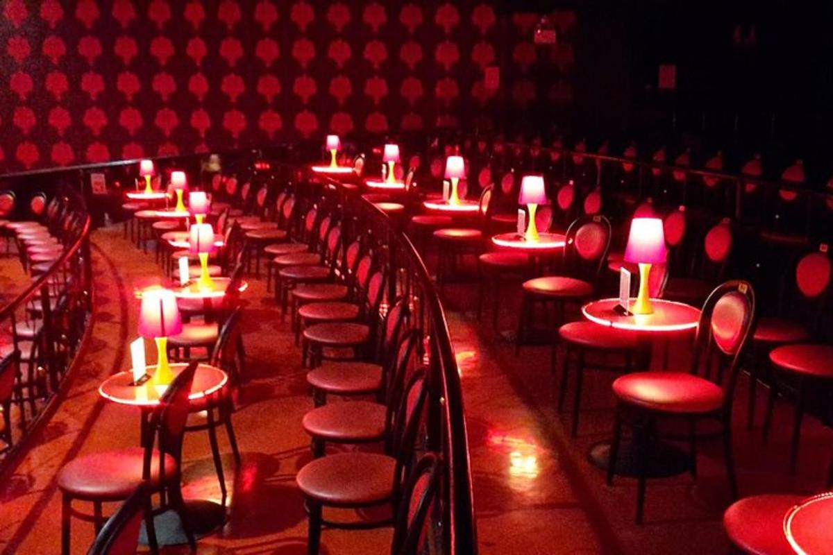 a row of tables in a theatre with candles on them