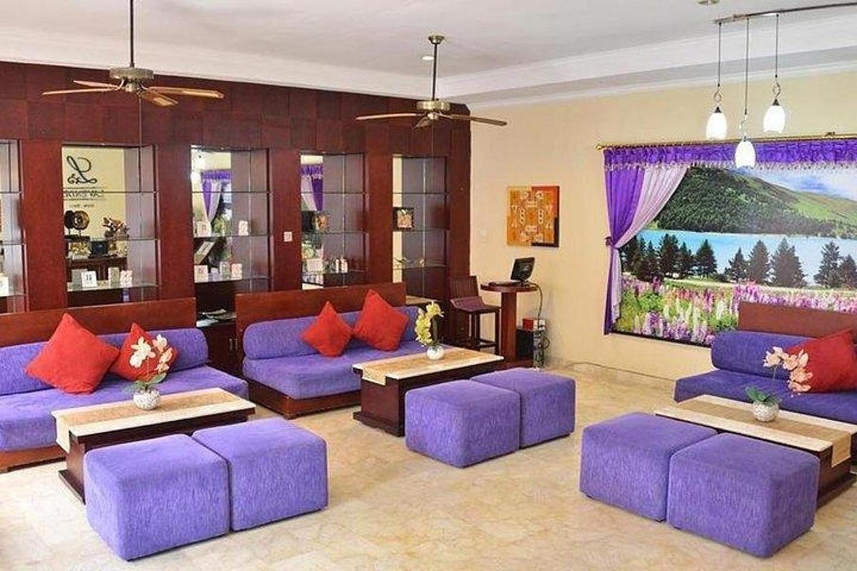 a living room with purple couches and a large painting