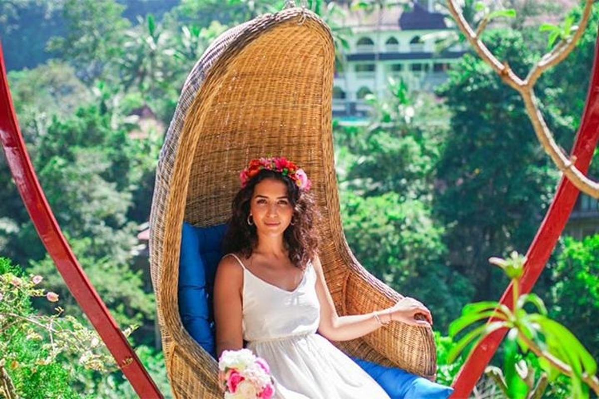 a woman is sitting in a wicker chair