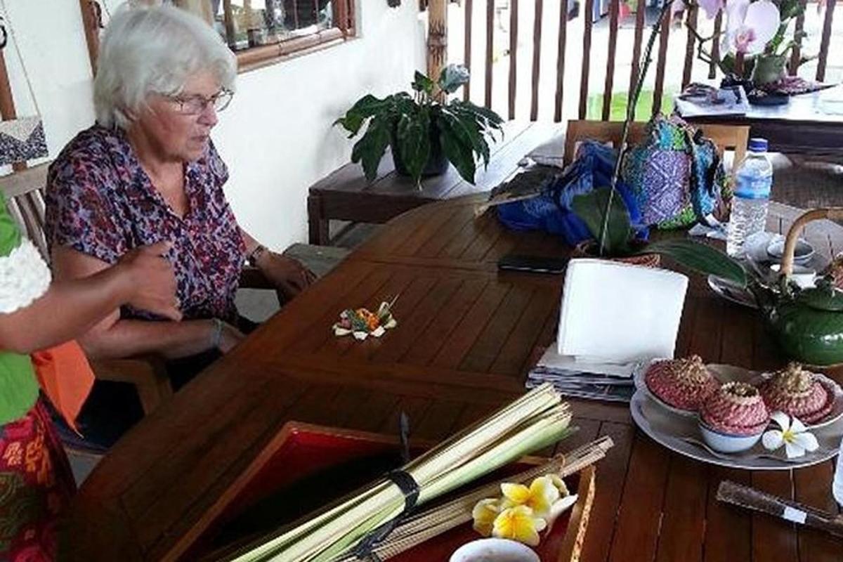 een oudere vrouw zittend aan een houten tafel