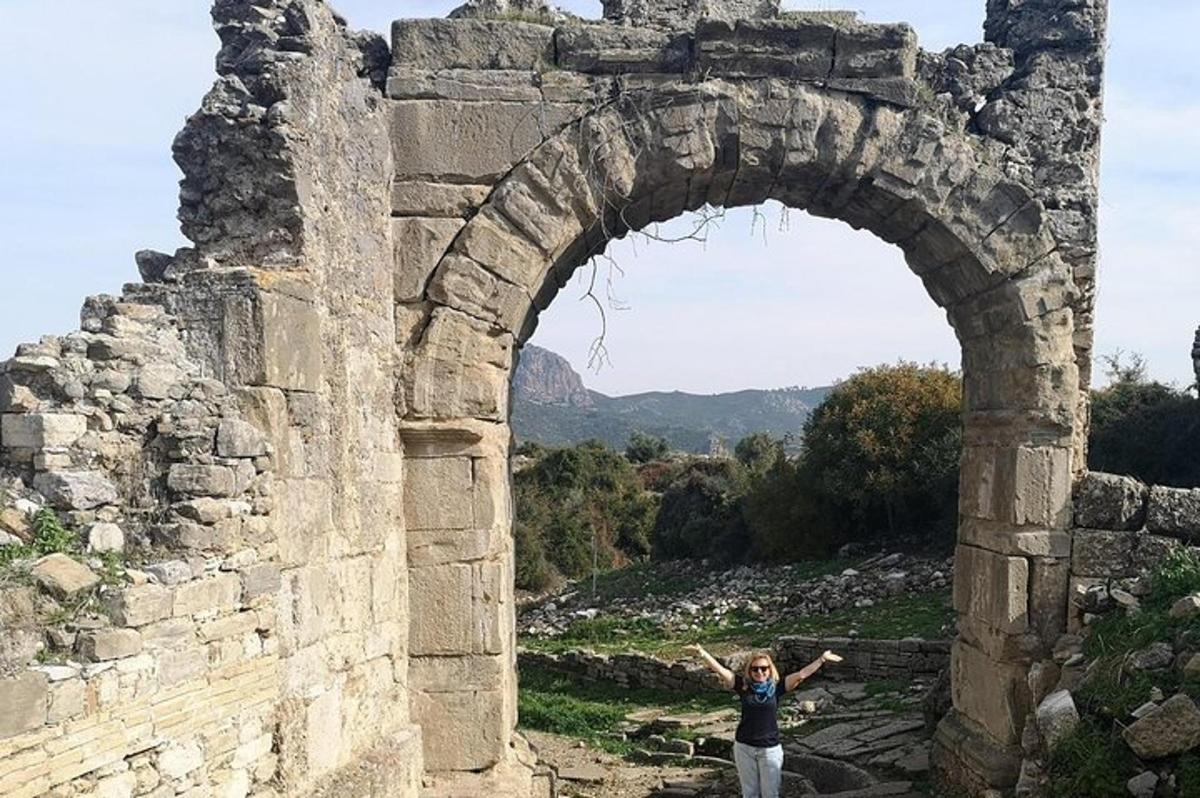 taş bir binanın kemerinde duran bir kadın