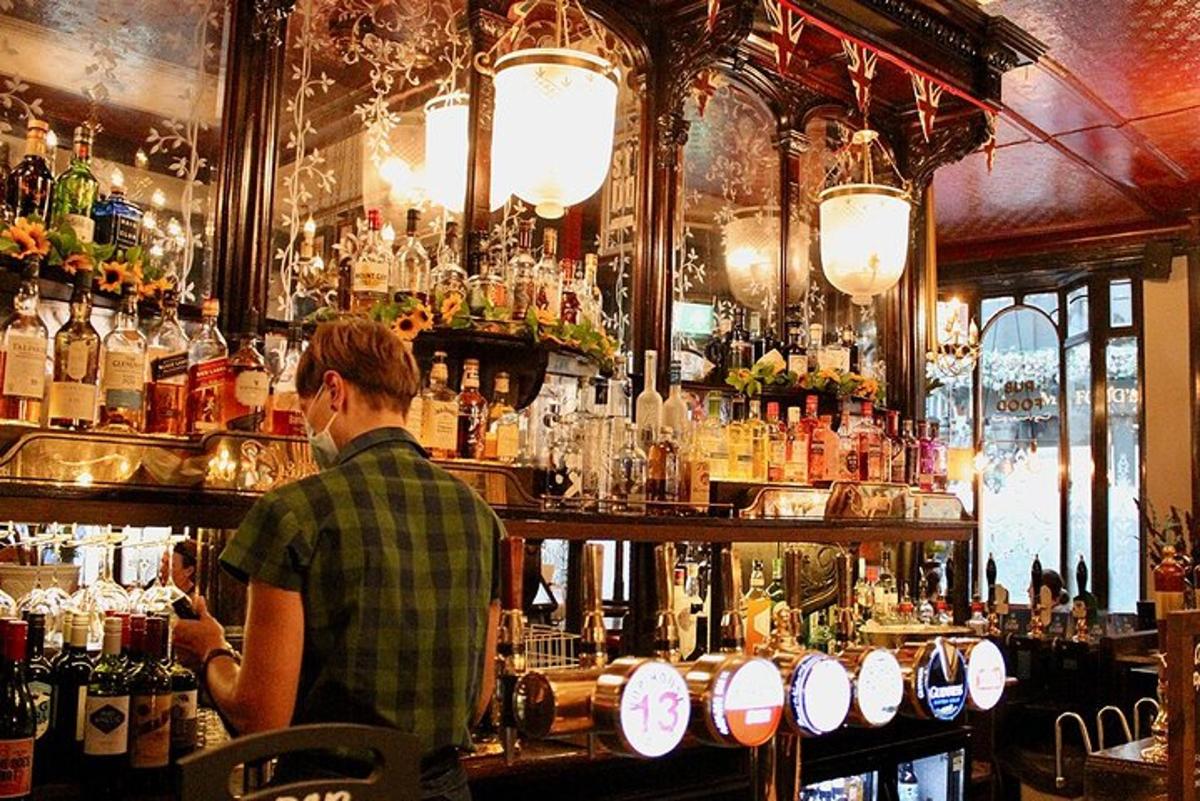 Maður stendur á bak við bar með fullt af drykkjum