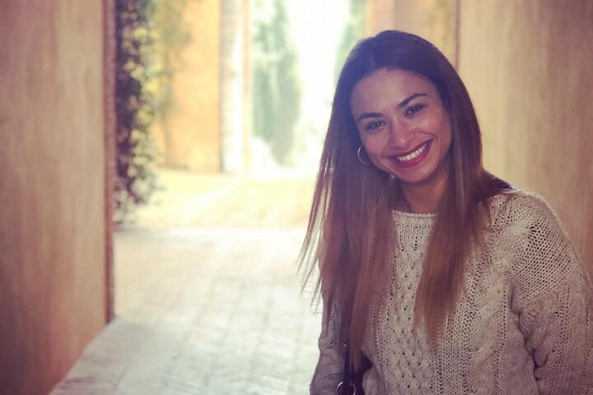 žena s dlouhými hnědými vlasy se usmívá do kamery