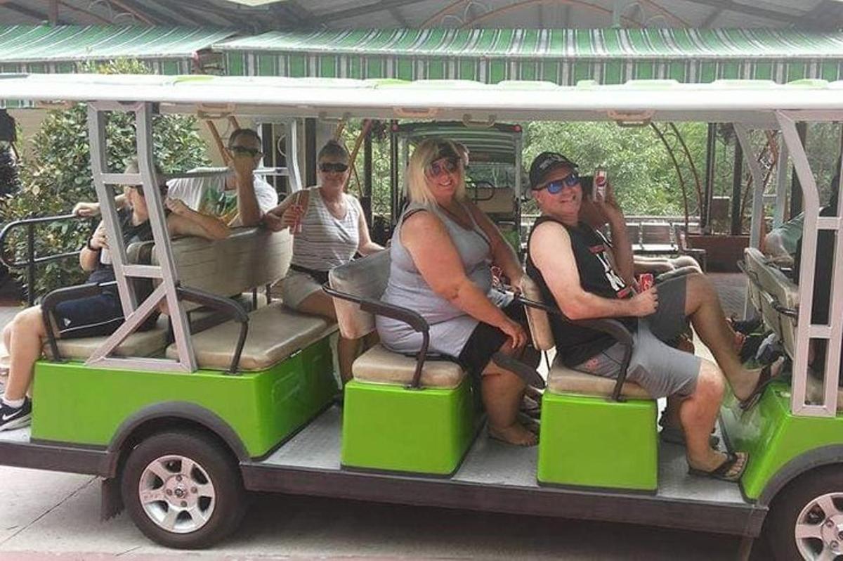 skupina lidí jedoucích v golfovém vozíku