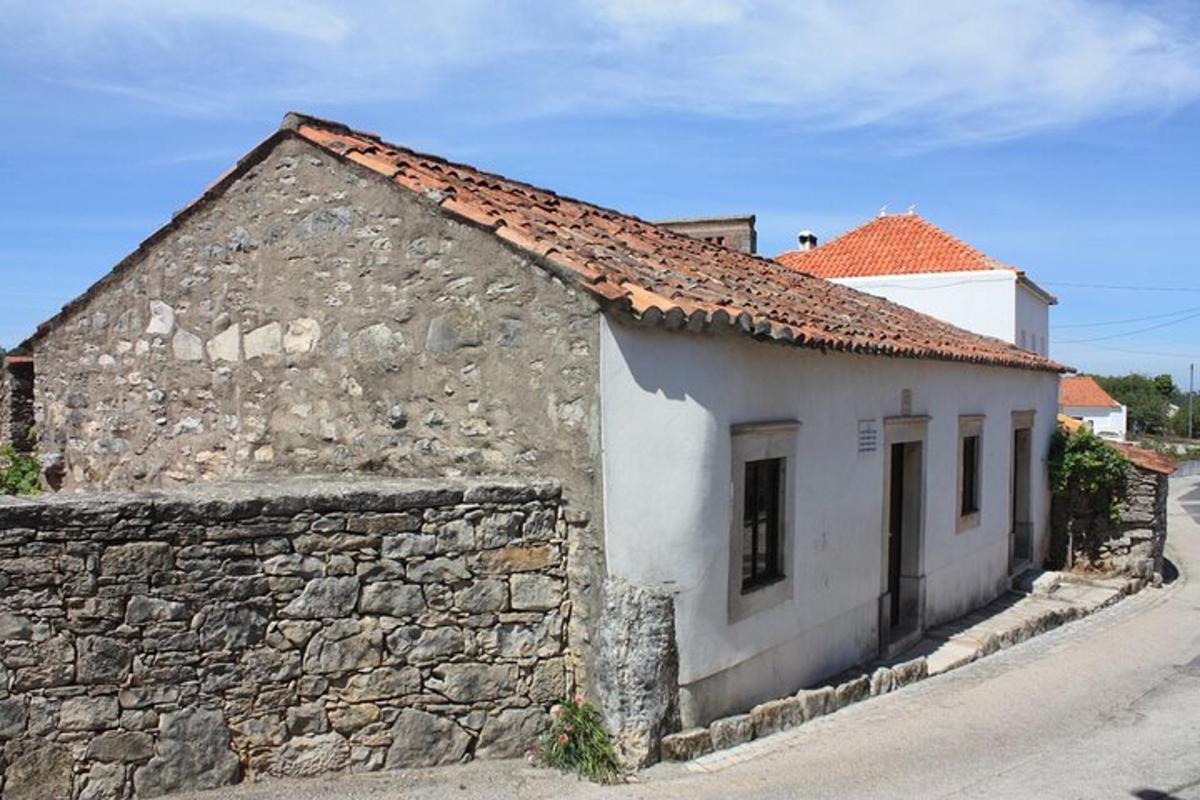 un vecchio edificio con un muro di pietra accanto a una strada