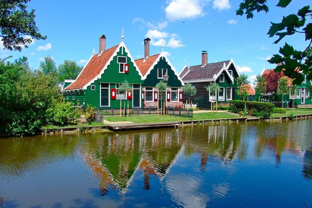 ein grünes Haus neben einem Fluss mit einem Haus