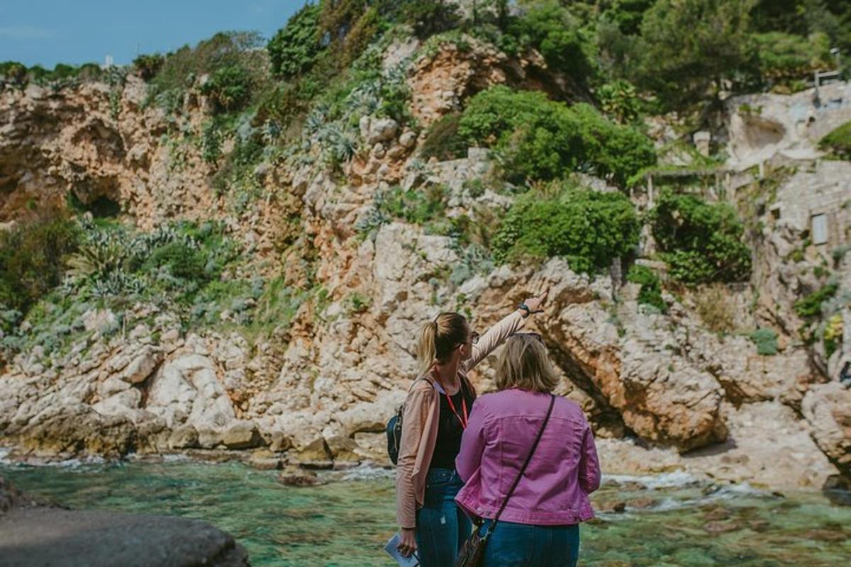 Dos mujeres están paradas en el agua cerca de una montaña.