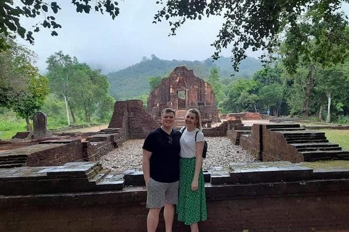 Un hombre y una mujer de pie frente a unas ruinas.