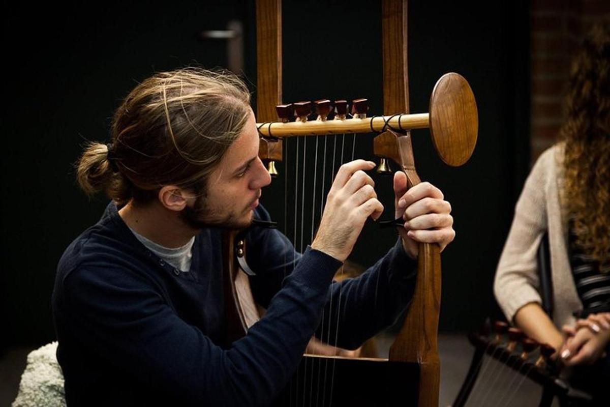 vīrietis fotografē vīrieti, kurš tur rokās koka instrumentu