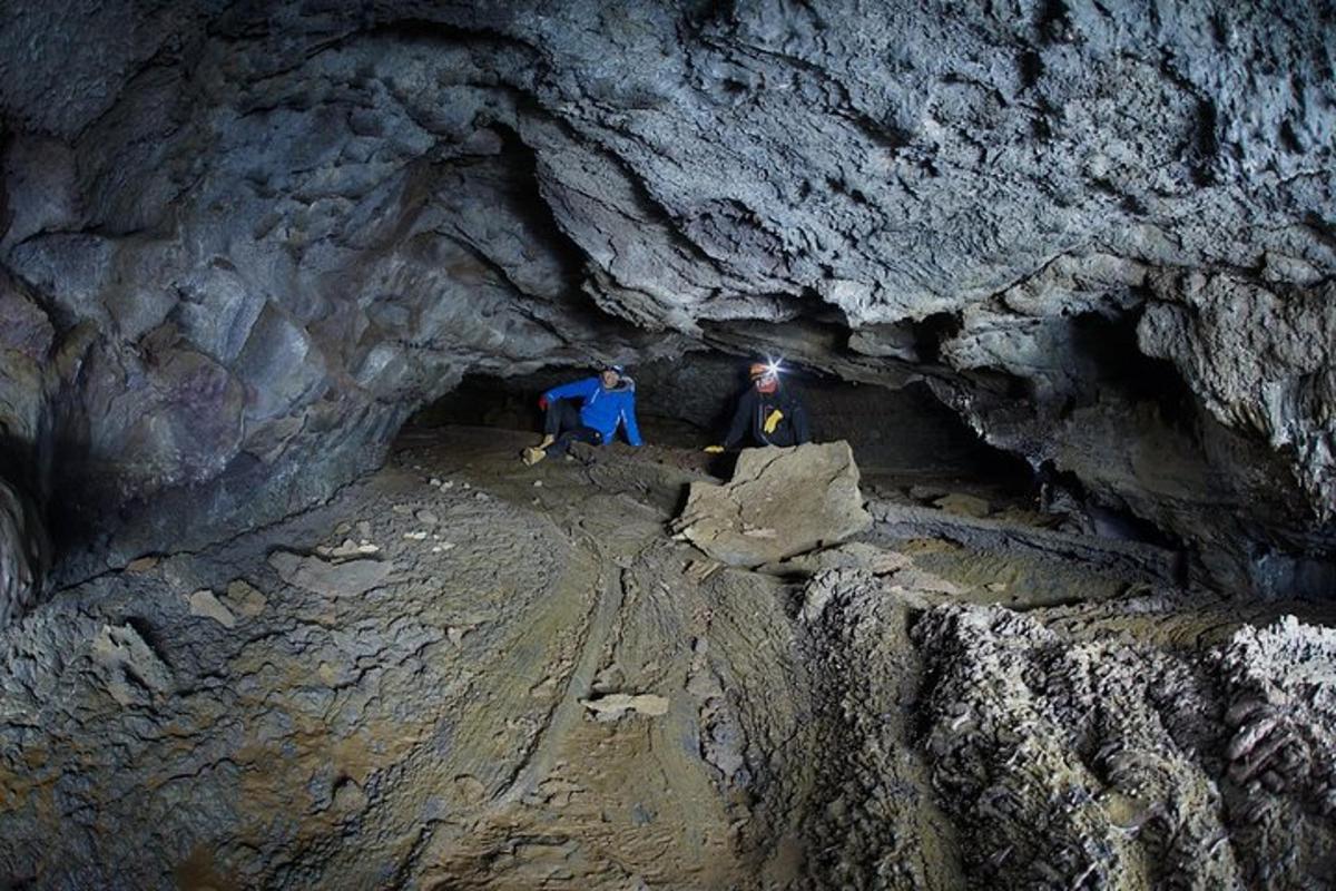 two people are standing in a cave