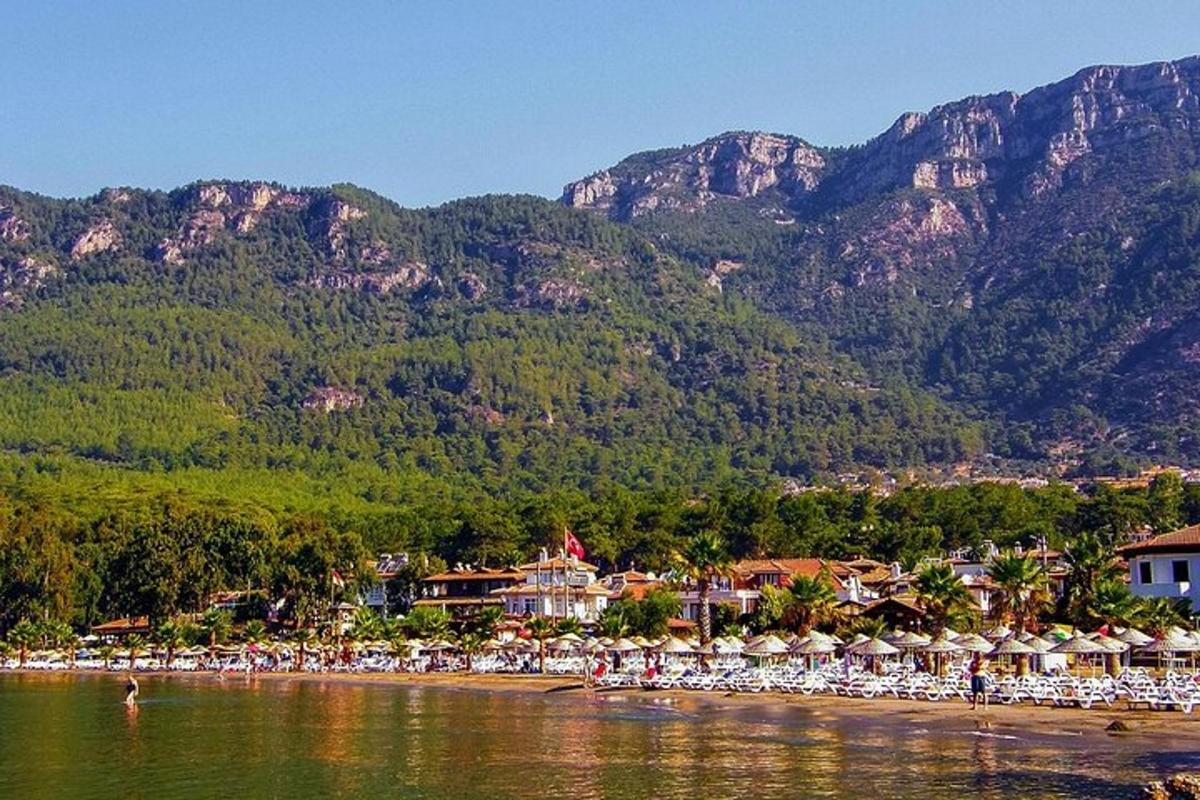 a beach with a resort and mountains in the background
