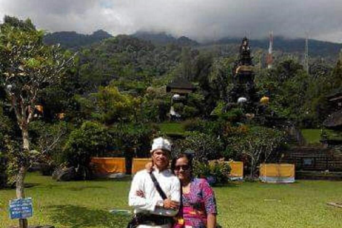 a man and woman standing in front of a temple