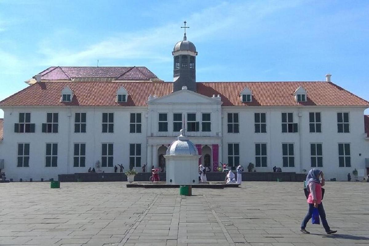 osoba kráčející před velkou budovou