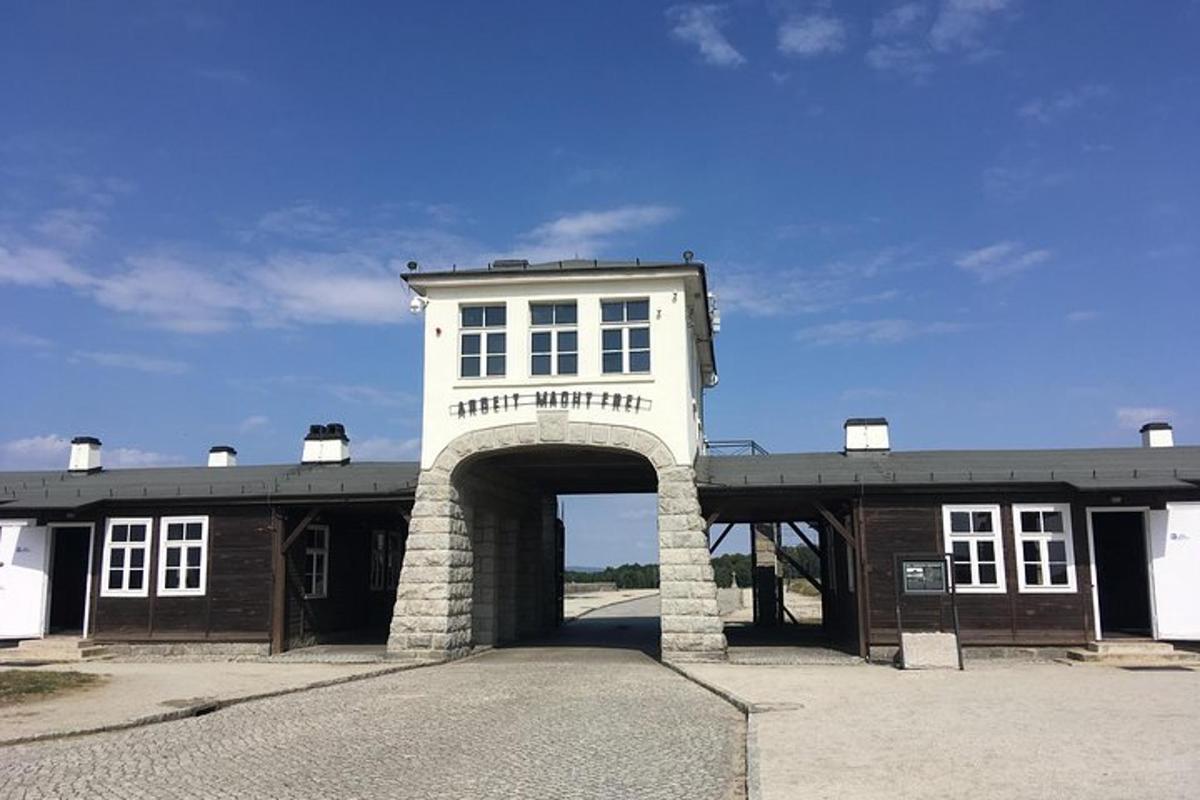 un gran edifici blanc amb un arc en un aparcament