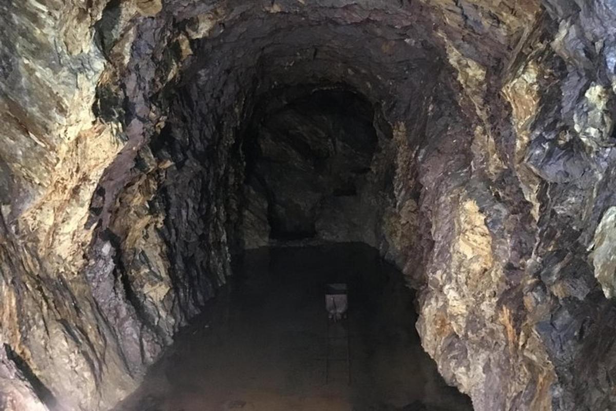 una cova fosca amb un túnel en una paret de roca