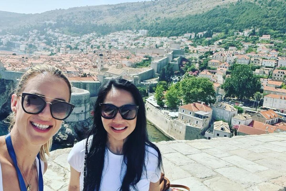 dvě ženy se slunečními brýlemi stojící na vrcholu města