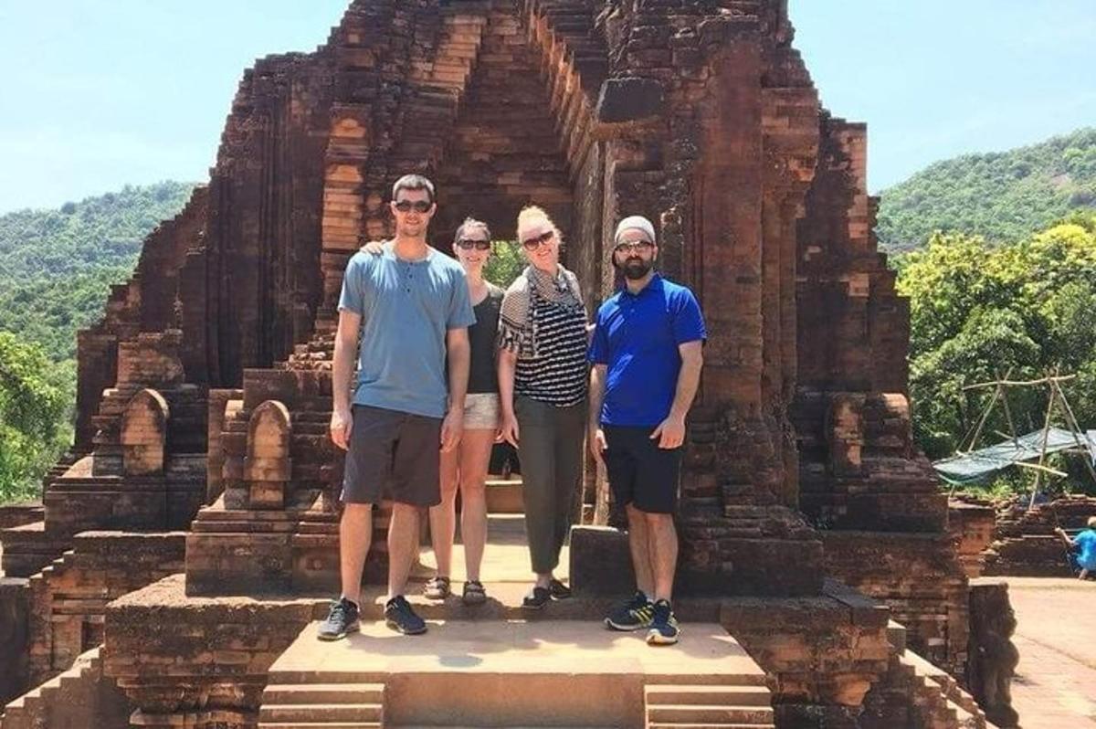 um grupo de pessoas em pé em frente a um templo