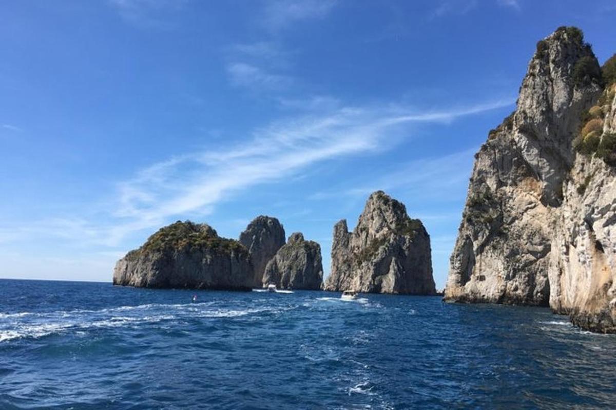 una barca in acqua vicino ad alcune isole rocciose