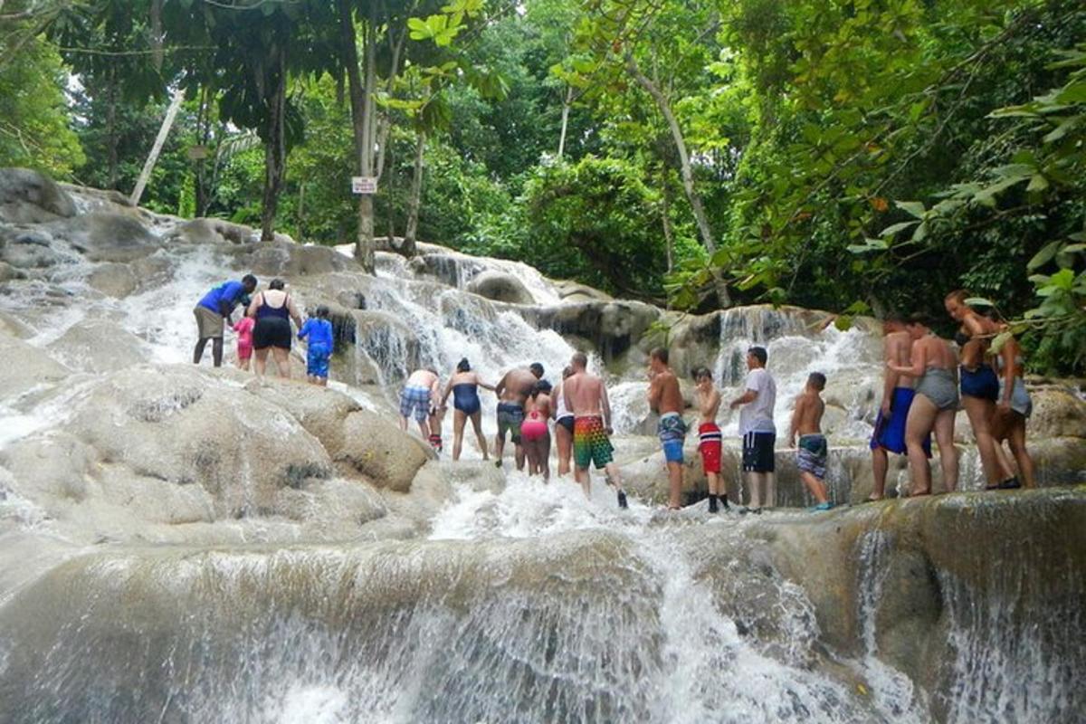 un grup de oameni care stau pe stânci într-o cascadă