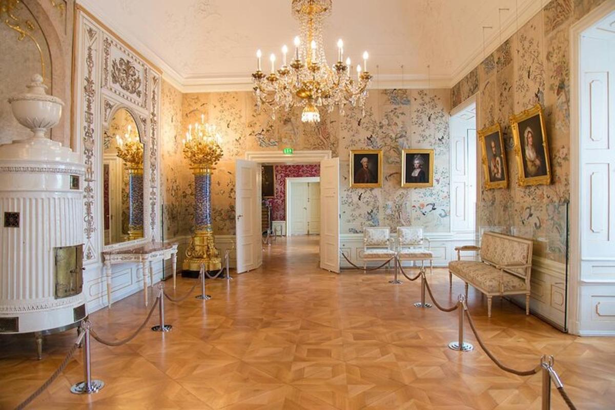 een grote kamer met een kroonluchter en schilderijen aan de muren