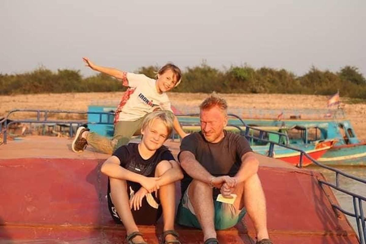 Mees ja kaks last istuvad paadi katusel
