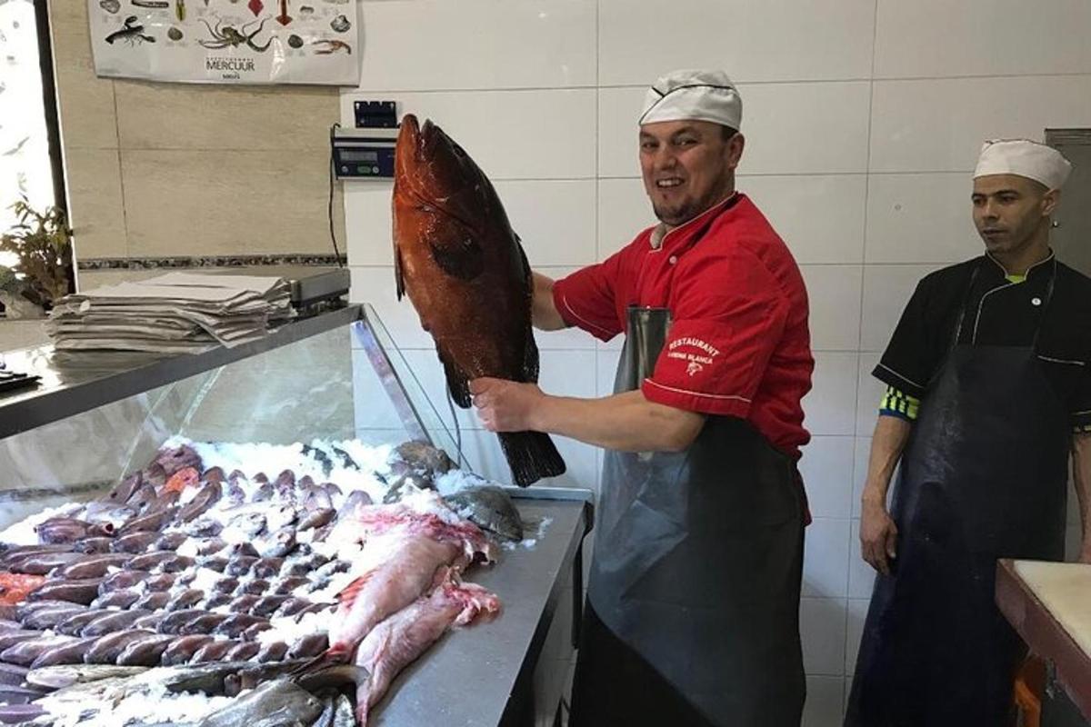 muž v kuchyni držící velký kus masa