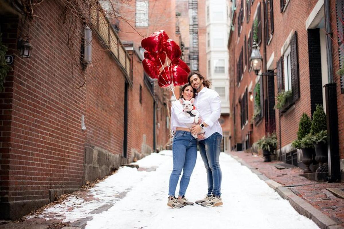 Un hombre y una mujer sosteniendo globos rojos en un callejón.