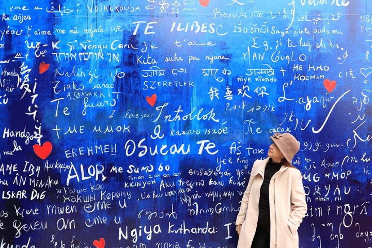 seorang wanita berdiri di depan dinding dengan tulisan di atasnya