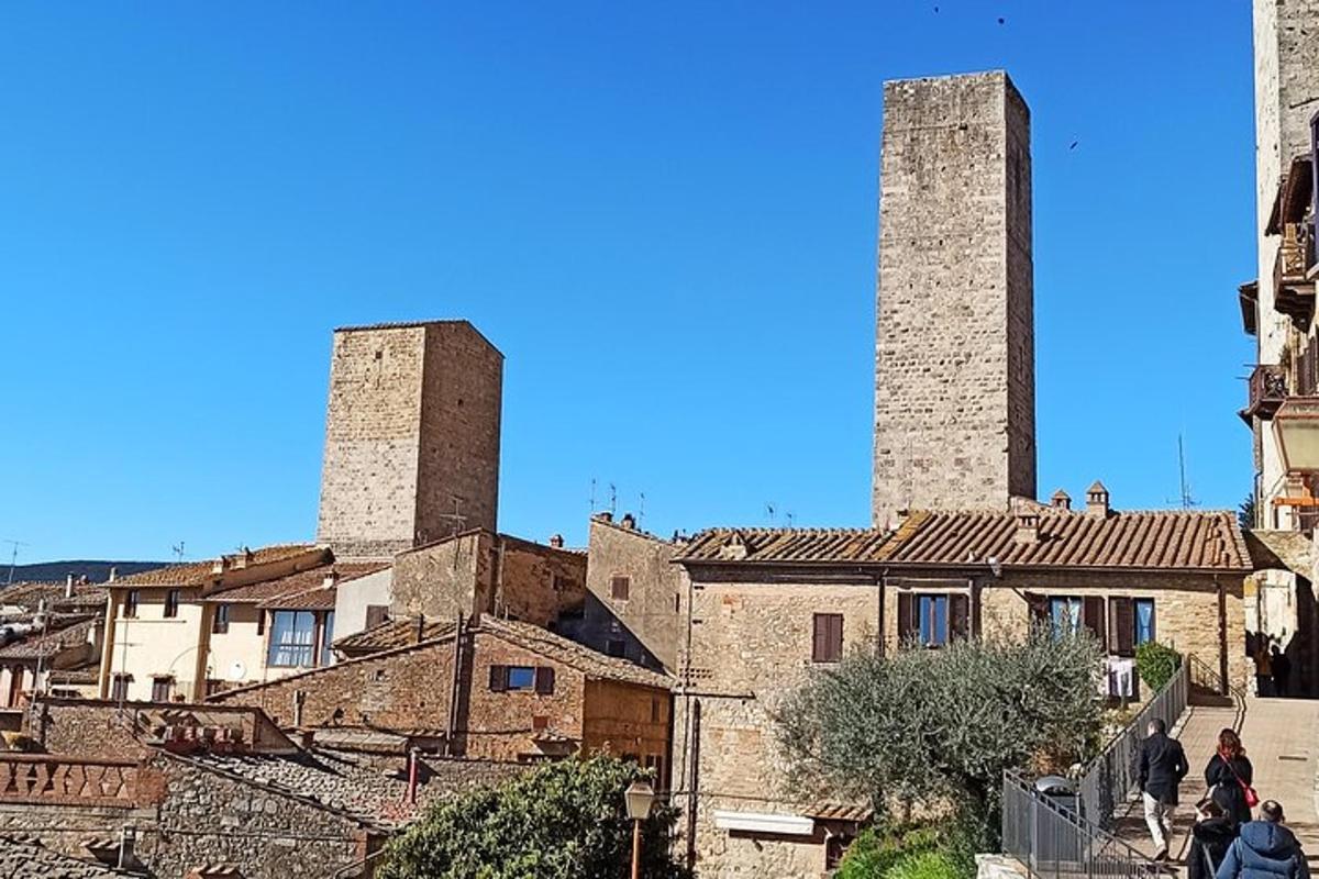 un grup de persones caminant per un carrer amb dues torres