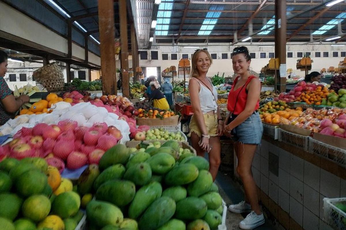 Δύο γυναίκες που στέκονται σε μια αγορά με φρούτα και λαχανικά
