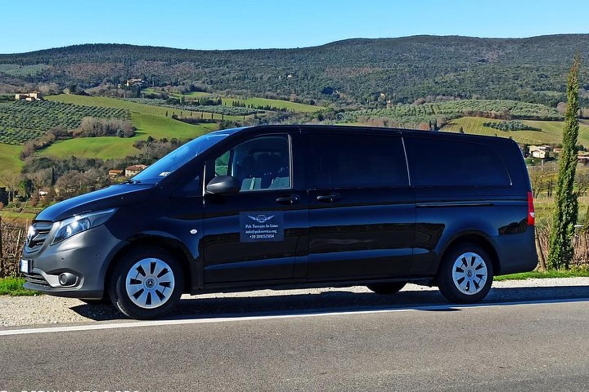 uma van preta estacionada na beira de uma estrada