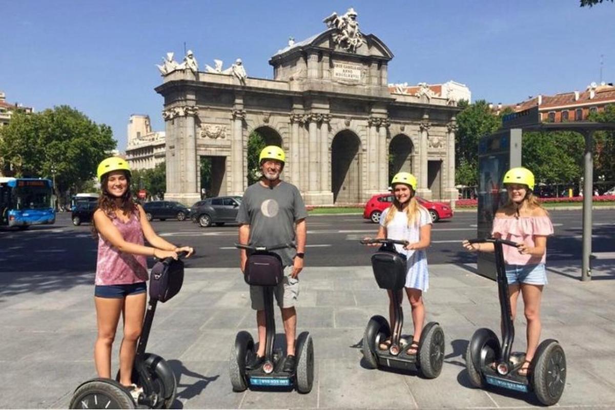 skupina lidí jedoucích na segwayích před budovou