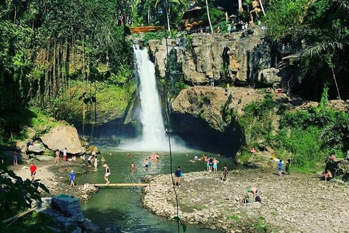 група људи у води код водопада