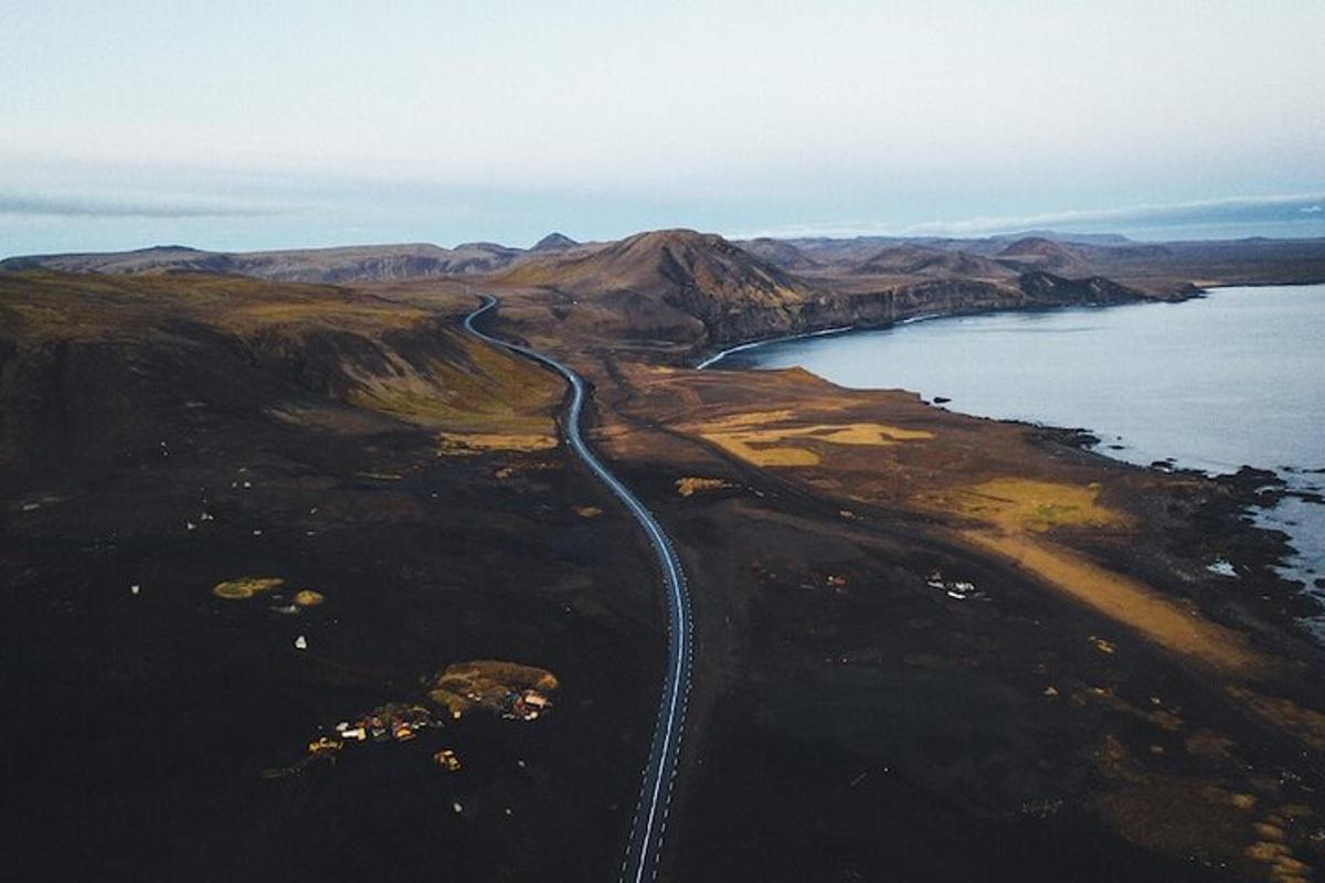 uma vista aérea de uma estrada em uma colina próxima à água